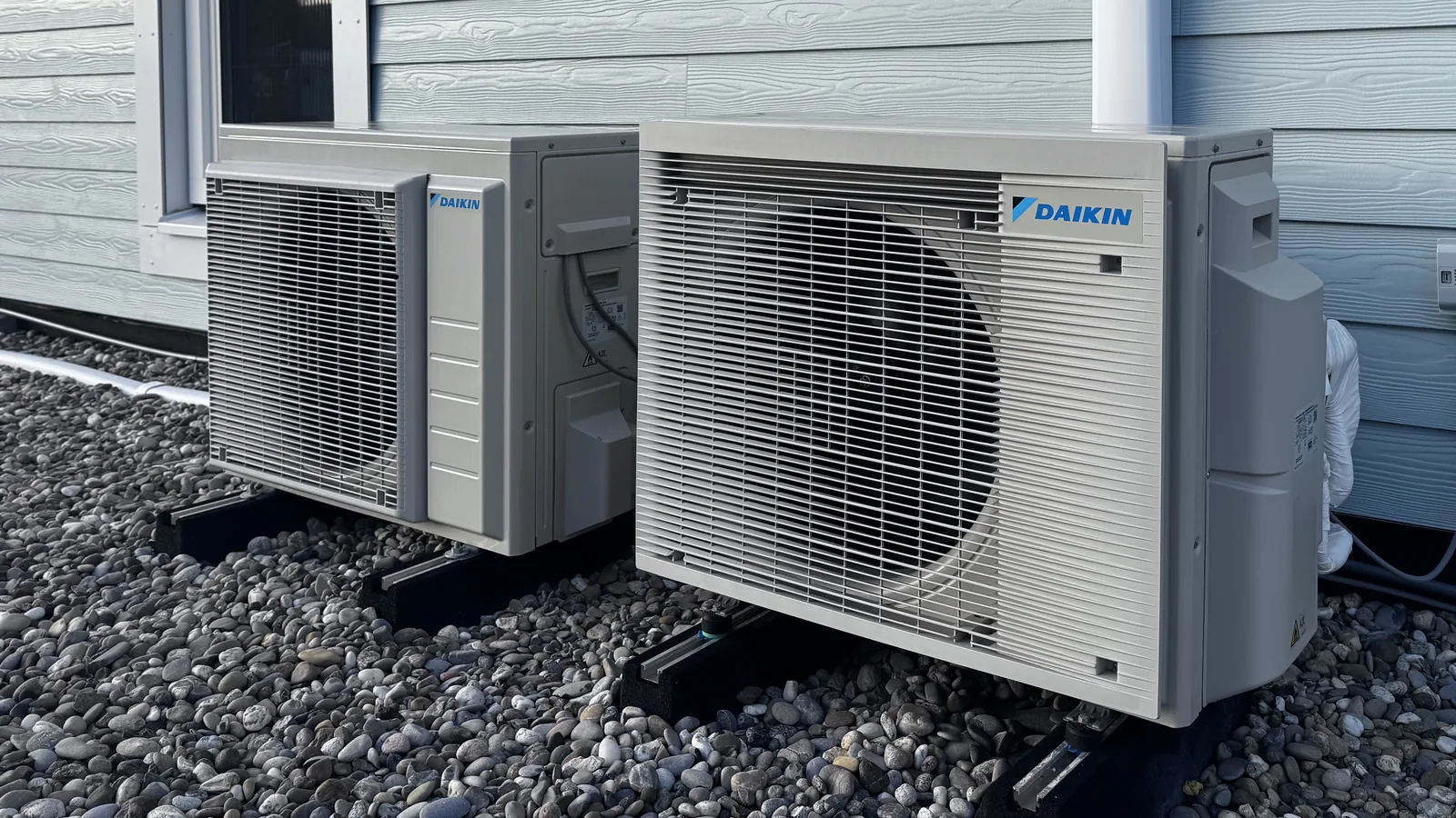 Daikin airco buitenunit met een tweede unit aan een blauwe houten gevel