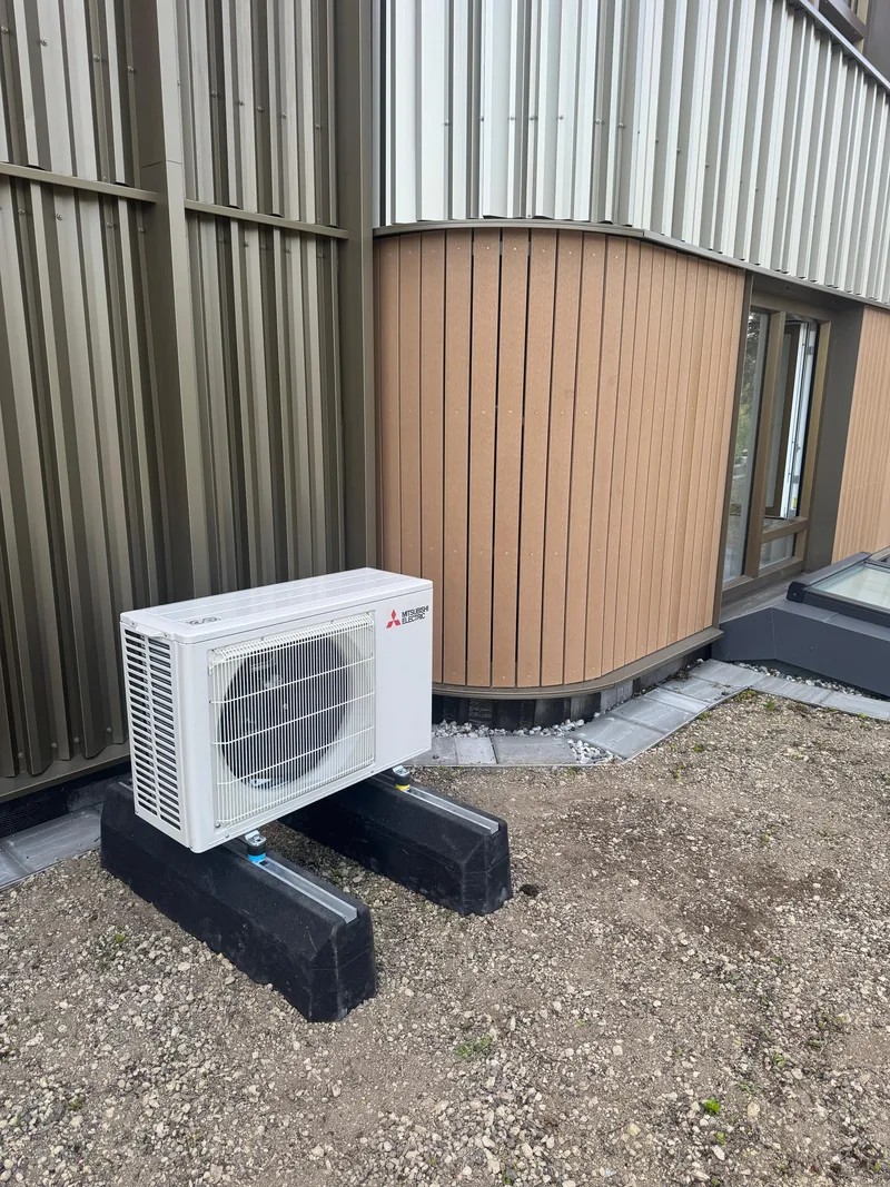 Mitsubishi Electric split-airco. Compacte Mitsubishi Electric buitenunit tegen de gevel van een woning, waterpas geplaatst door HEAT Nederland.