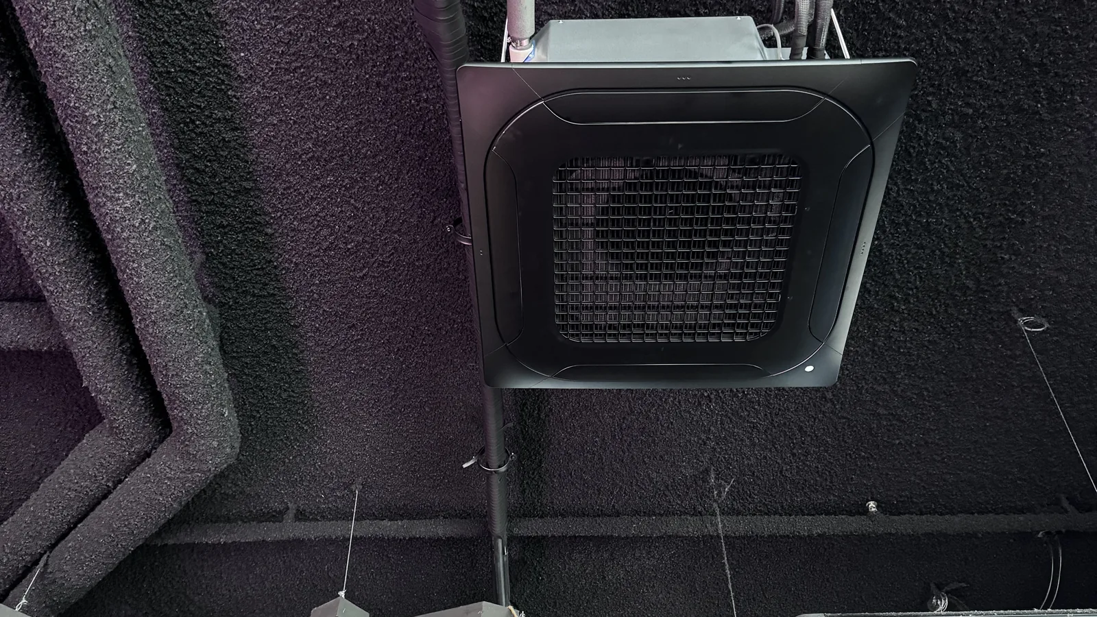 Zwarte airco-plafondcassette in een horecazaak