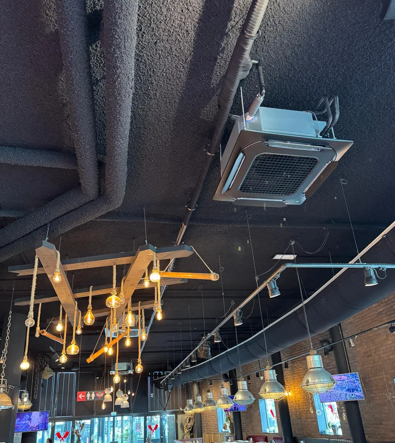 Zwarte plafondcassette in de horeca. Zwarte plafondcassette in een donkere horecazaak, geplaatst door HEAT Nederland. Strak weggewerkt, met 4-wegs luchtverdeling.