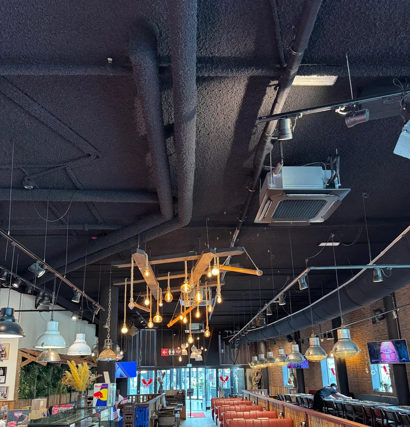 Zwarte plafondcassette in de horeca. Zwarte plafondcassette in een donkere horecazaak, geplaatst door HEAT Nederland. Strak weggewerkt, met 4-wegs luchtverdeling.