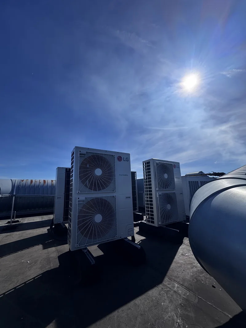 LG buitenunits op een bedrijfsdak. Bedrijfsdak vol LG buitenunits, strak op stelrails en trillingsdempers geplaatst door HEAT Nederland.