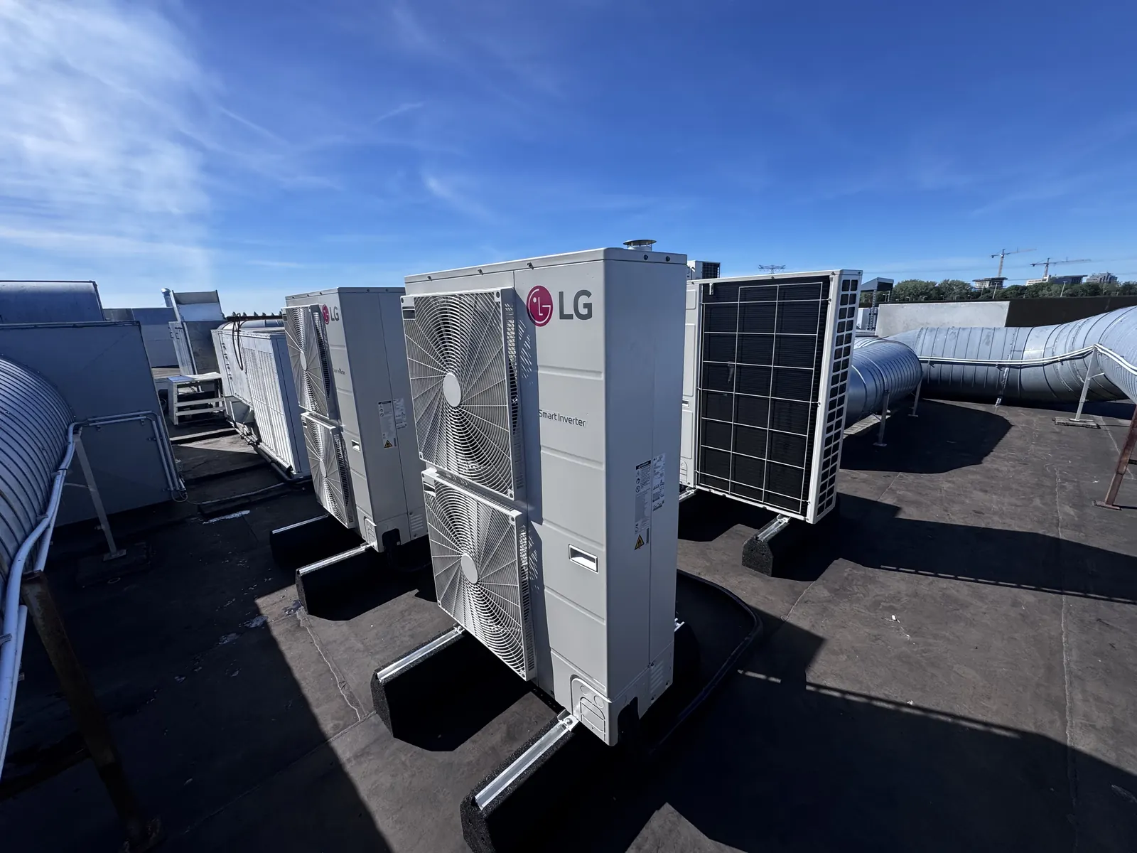 LG buitenunits op een bedrijfsdak. Bedrijfsdak vol LG buitenunits, strak op stelrails en trillingsdempers geplaatst door HEAT Nederland.